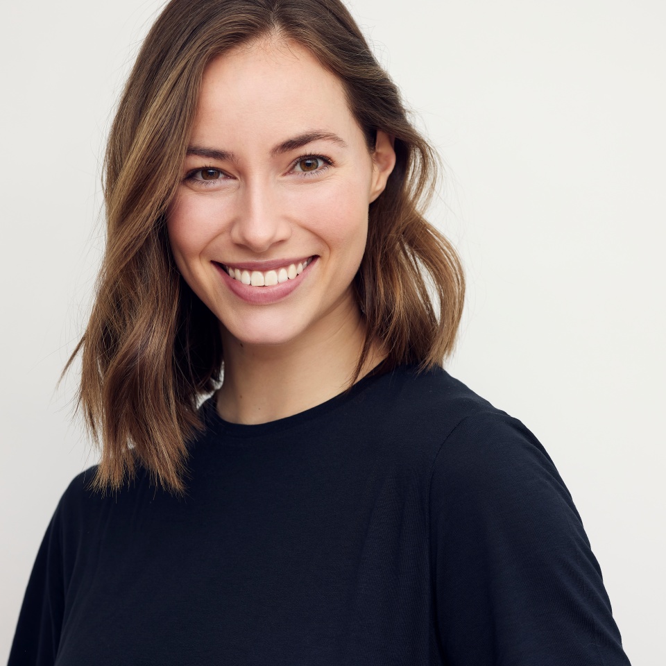 Portrait of beautiful natural brunette woman, smiling and looking in camera with white teeth. Close-up portrait of cute female girl in black t-shirt isolated on white background.